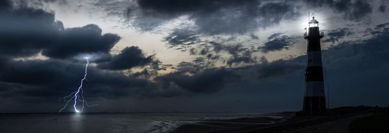 Lightning striking a body of water near a lighthouse